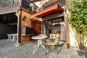 a patio with a table and chairs in front of a building at La Maison au bord du Lac in Chemillé-sur-Indrois