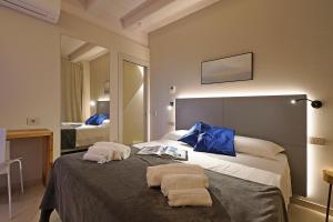 a bedroom with a bed with two towels on it at Lamasu RioVerde - Lago di Garda in San Felice del Benaco