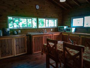 a kitchen with a table and chairs in a cabin at Cabaña Ilusión - Complejo Marea in Tigre