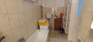 ein Badezimmer mit einer Badewanne und einem Waschbecken in der Unterkunft Júlia Apartman. in Budapest