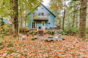 ein blaues Haus mit Stühlen davor in der Unterkunft Wildwood Cabin in Welches