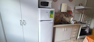 ブダペストにあるJúlia Apartman.の白い冷蔵庫と電子レンジのあるキッチン +6枚の写真