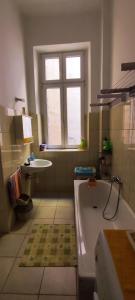 ein Bad mit einer Badewanne, einem Waschbecken und einem Fenster in der Unterkunft Júlia Apartman. in Budapest