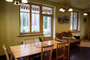 a dining room with a wooden table and chairs at LVM tūrisma un atpūtas centrs "Spāre" in Spāre