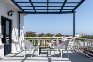 patio z krzesłami i stołem na balkonie w obiekcie Rivari Santorini Hotel w mieście Kamari