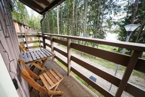 a porch with a wooden bench and a table at LVM tūrisma un atpūtas centrs "Spāre" in Spāre