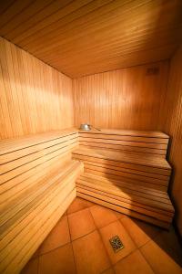 a corner of a wooden sauna with a tile floor at LVM tūrisma un atpūtas centrs "Spāre" in Spāre