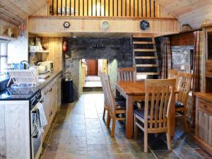 a kitchen with a table and chairs and a staircase at Capercaillie Cottage in Rhilochan