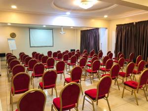 a conference room with red chairs and a projection screen at Sonia Hotel in Accra +53 photos