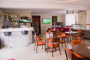 a restaurant with tables and chairs and a bar at Sonia Hotel in Accra
