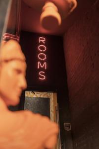 a man standing in front of a neon sign at Globe Runner Hostel in Kyiv