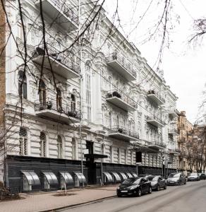 ein großes weißes Gebäude mit davor geparkt in der Unterkunft Globe Runner Hostel in Kiew