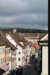 uma vista para uma rua da cidade com edifícios e carros em Albergo Diffuso Porrentruy em Porrentruy