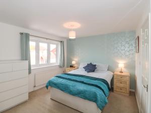 a bedroom with a bed with a blue wall at Sandy Toes in Christchurch