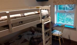 A bed or beds in a room at The Rockhouse - Cosy stone built Thatch Cottage