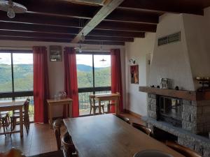 a dining room with a table and a fireplace at Les chalets du belvédère de mallet in Sarrus