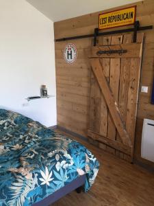 - une chambre avec un lit et une porte en bois dans l'établissement Gîte à broc à 5 minutes de Plombières les Bains, à Plombières-les-Bains