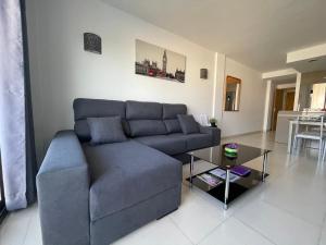 a living room with a blue couch and a table at Samsara Beach in Port d'Alcudia