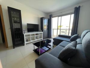 a living room with a couch and a tv at Samsara Beach in Port d'Alcudia