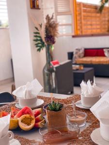 a table topped with bowls of fruit on a table at Hotel Oasis in Grande Anse