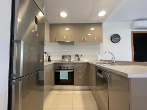 a kitchen with a stainless steel refrigerator and a sink at Samsara Beach in Port d'Alcudia