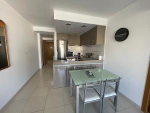 a kitchen with a table and chairs and a clock on the wall at Samsara Beach in Port d'Alcudia