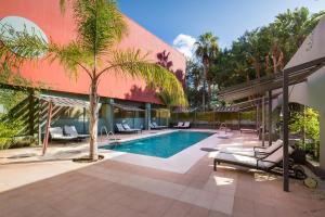 a house with a pool and a palm tree at Barceló Marbella in Marbella