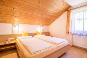 a large bed in a room with a wooden ceiling at Kuglerhof Apt 1 in Cadipietra