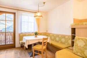 - une salle à manger avec une table et un canapé dans l'établissement Kuglerhof Apt 2, à Cadipietra