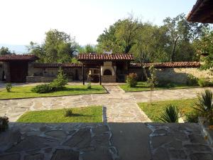 a house with a stone patio and a yard at кьща за гости Свети Никола in Zheravna