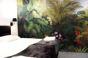 sypialnia z malowidłem roślinnym i łóżkiem w obiekcie Lyck Apartamenty w mieście Ełk