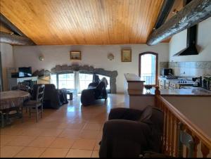 a living room with couches and a table and a kitchen at Appartement d'exception sur le port pittoresque de Marseillan in Marseillan