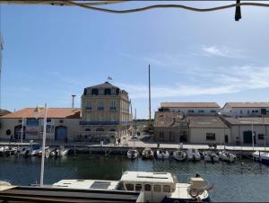 Appartement d'exception sur le port pittoresque de Marseillan في مارسيلان: مجموعة قوارب مرساة في مرسى مع مباني