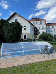 einem großen Pool mit zwei Stühlen vor einem Gebäude in der Unterkunft Apartmán v Zahradní in Prachatice