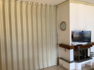 a room with a tv and a curtain at Condominio Andromeda Seeblick in Locarno