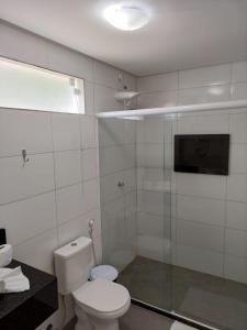a bathroom with a toilet and a glass shower at Pousada Sunset Boipeba in Ilha de Boipeba
