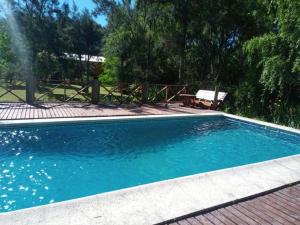 a swimming pool with blue water and a bench at Cabaña Ilusión - Complejo Marea in Tigre +42 photos
