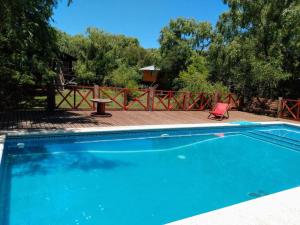 a blue swimming pool with a red chair in a yard at Cabaña Ilusión - Complejo Marea in Tigre