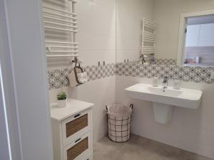 ミエルノにあるRezydencja Park Mielno Lake Viewの洗面台と鏡のある白いバスルーム +39枚の写真