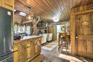 cocina y sala de estar con paredes y techos de madera. en Rustic Retreat with Hot Tub in North Branford!, en North Branford