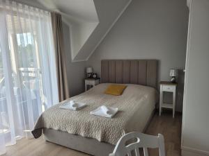 ミエルノにあるRezydencja Park Mielno Lake Viewのベッドとタオル2枚のある寝室