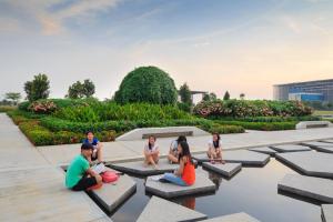 a group of people sitting on benches in a park at Zillion Cozy - Trefoil Setia Alam- Next to Setia City Mall & Convention Centre in Shah Alam