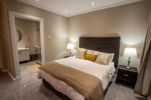a bedroom with a large bed and a bathroom at Stay at The Point- Royal Relaxing Retreat in Durban
