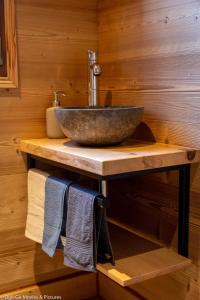 a bathroom with a sink and a counter with towels at Les Jardins du Hérisson Chalet 1 in Bonlieu