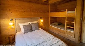 a bedroom with a bed and two bunk beds at Les Jardins du Hérisson Chalet 1 in Bonlieu