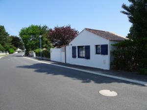 una piccola casa bianca sul lato di una strada di Belle petite maison pour des vacances en duo sur l'île de Noirmoutier a La Guérinière
