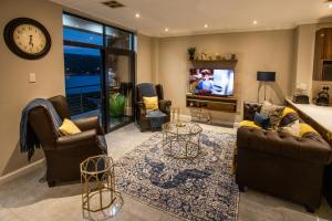 a living room with couches and a flat screen tv at Stay at The Point- Royal Relaxing Retreat in Durban