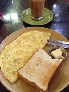 a plate of eggs and toast with a piece of butter at HOTEL HAIFA in Varanasi