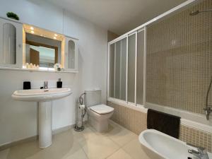 a bathroom with a sink and a toilet and a mirror at Samsara Beach in Port d'Alcudia