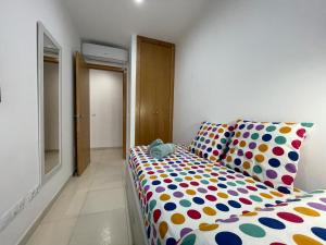 a bedroom with a bed with a polka dot blanket at Samsara Beach in Port d'Alcudia